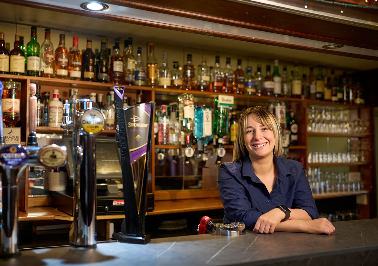 The General Manager smiling behind the bar at Ulbster Arms Hotel