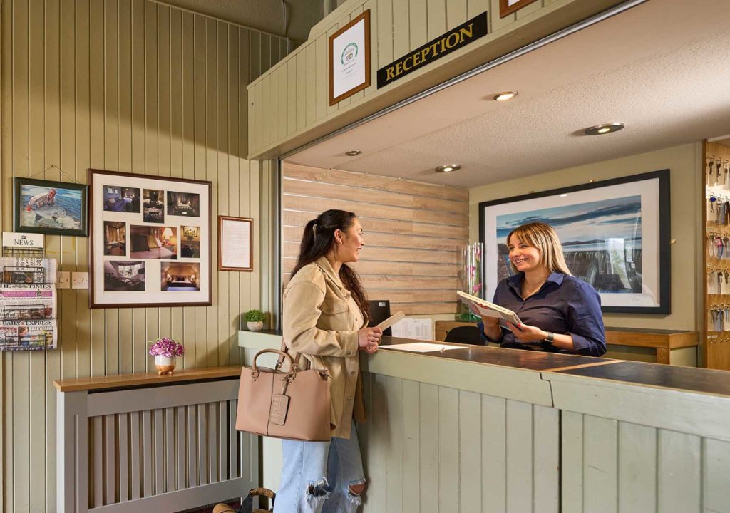 A friendly receptionist greeting a guest at reception in The Ulbster Arms Hotel in Caithness