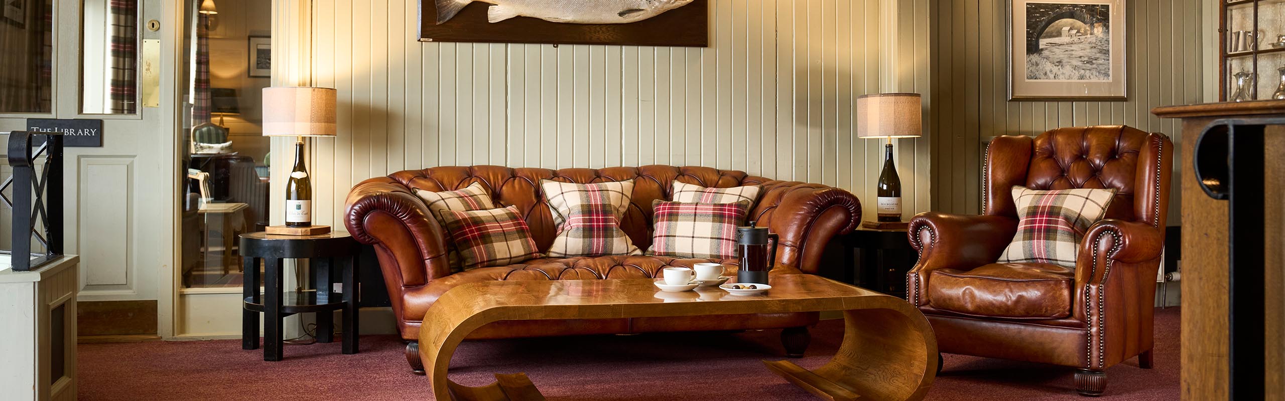 A leather Chesterfield sofa and wingback armchair in the Lounge at the Ulbster Arms Hotel in Caithness