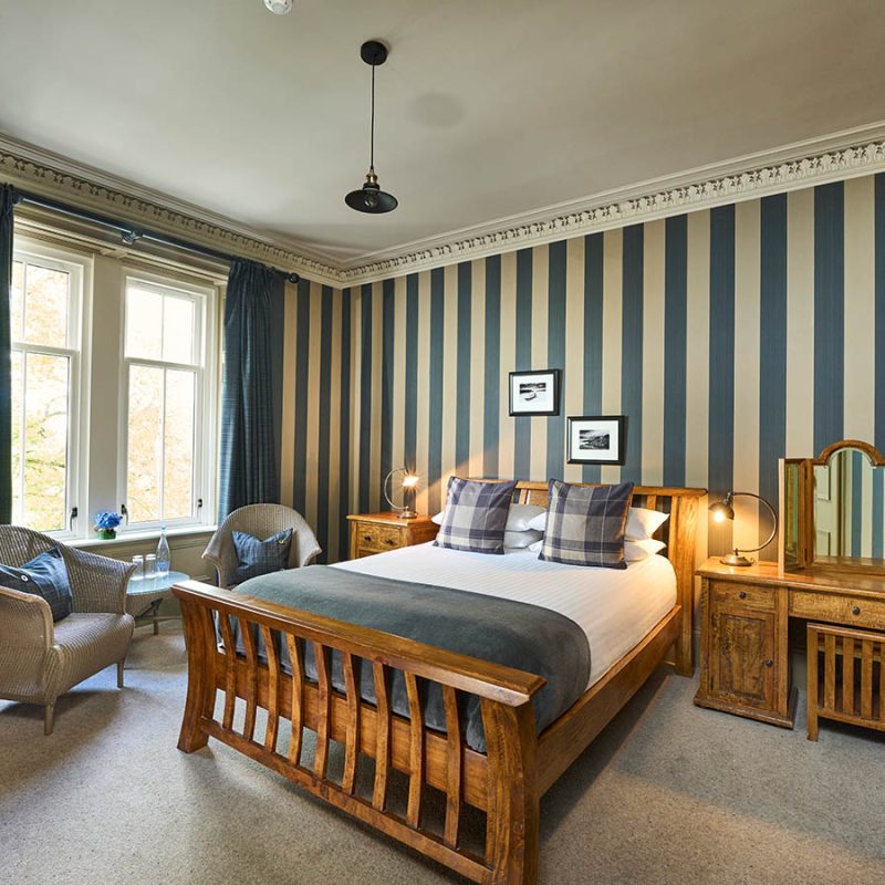 A Pet Friendly Room in the Ulbster Arms Hotel in Caithness with luxury wooden furnishings and statement striped wallpaper