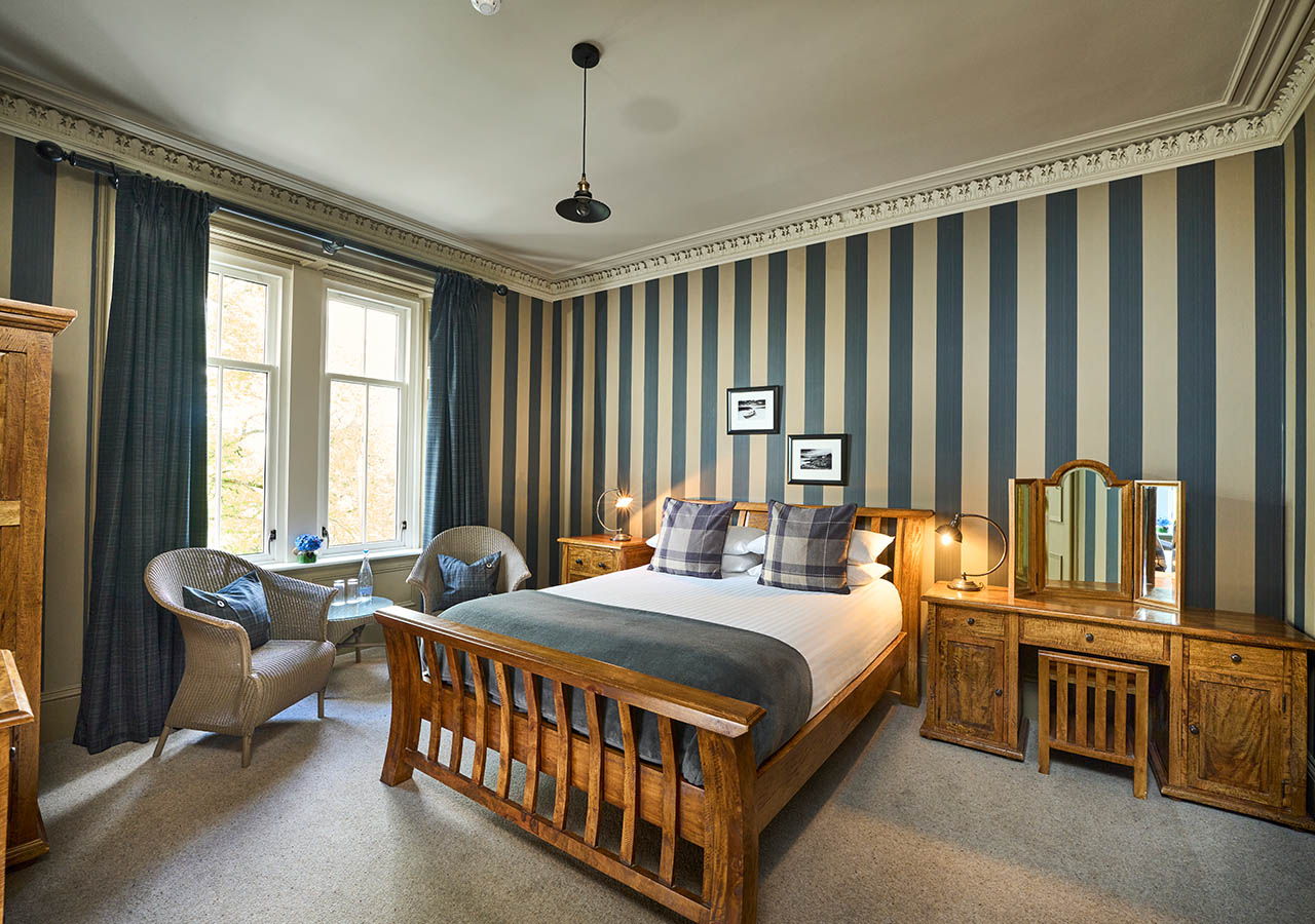 A Pet Friendly Room in the Ulbster Arms Hotel in Caithness with luxury wooden furnishings and statement striped wallpaper