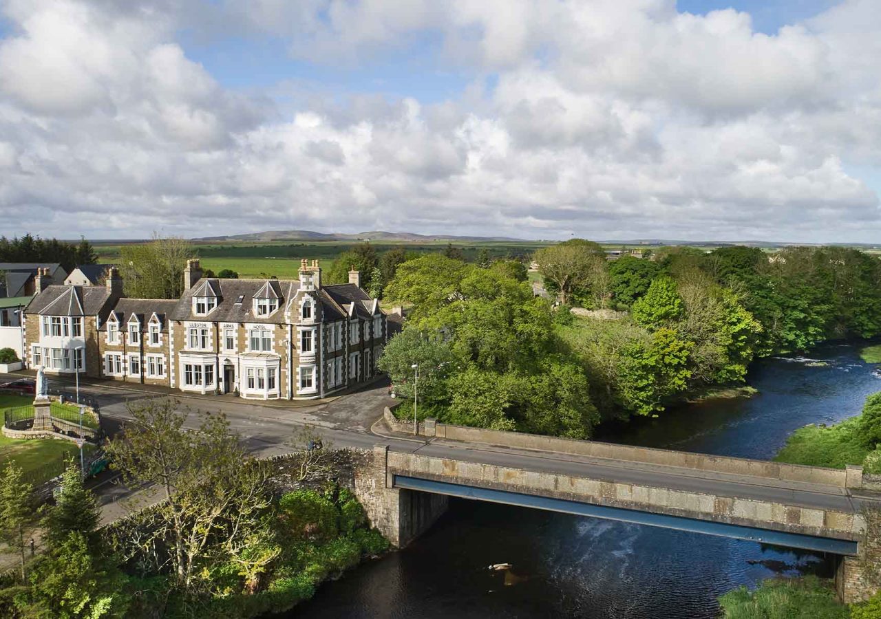 An aerial view of the Ulbster Arms Hotel in Caithness with the River Thurso running by it