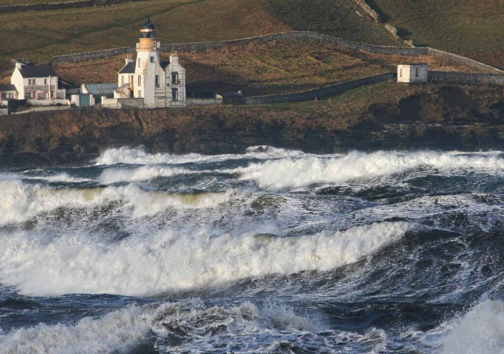 Scrabster on a stormy day with crashing waves.