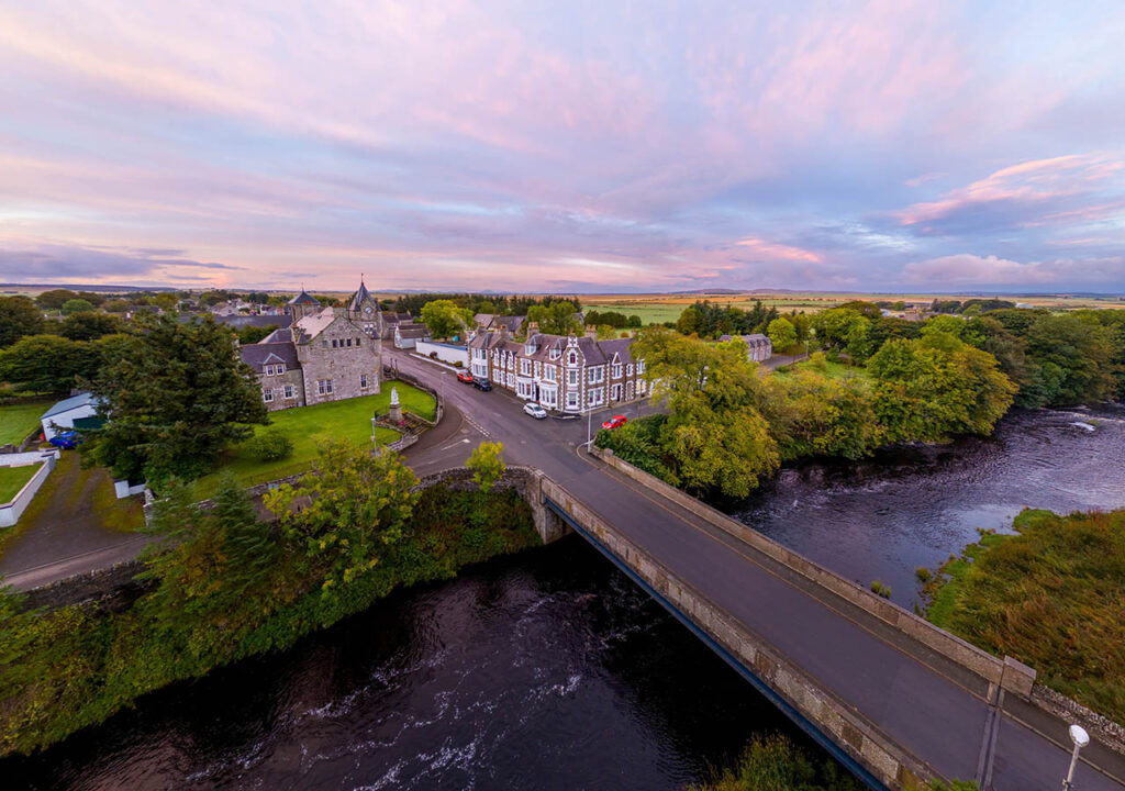 An aerial view of the Ulbster Arms Hotel in Halkirk showing its rural landscape and location at sunset