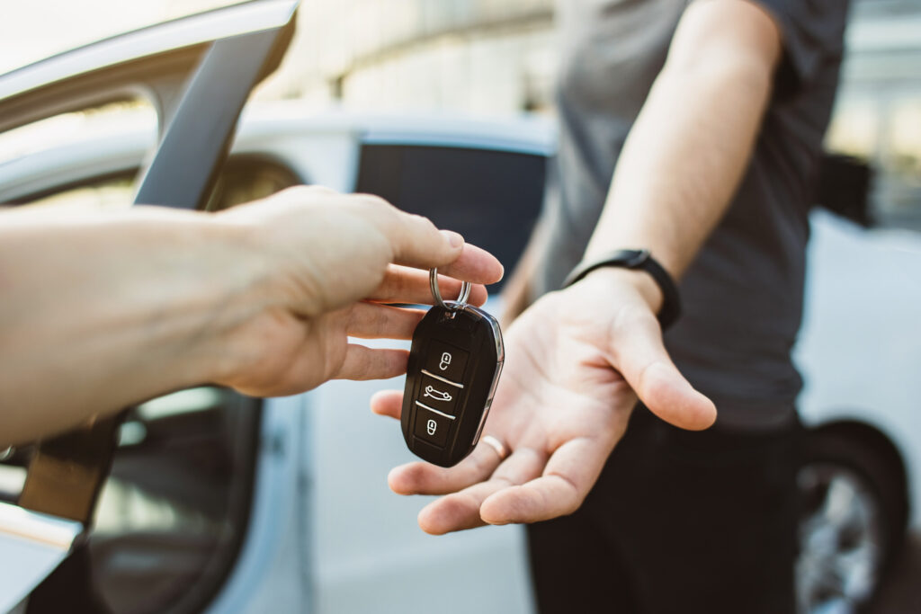 Close-up of handing over hire car keys