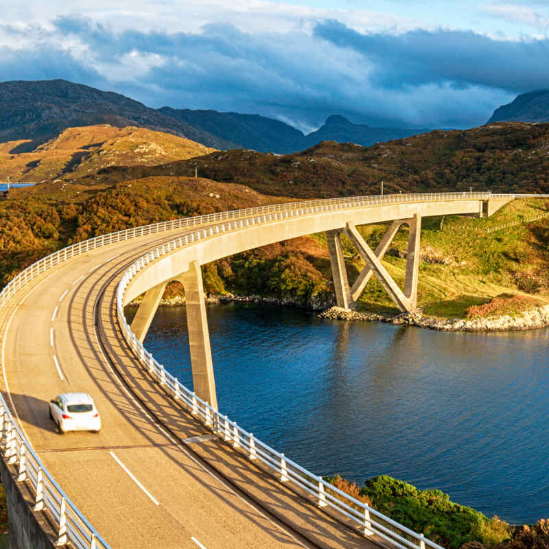 A white car on the Kylesku Bridge in the Scottish Highlands