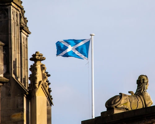 The Scottish Flag flying on a windy day on a flag pole at a Scottish castle.