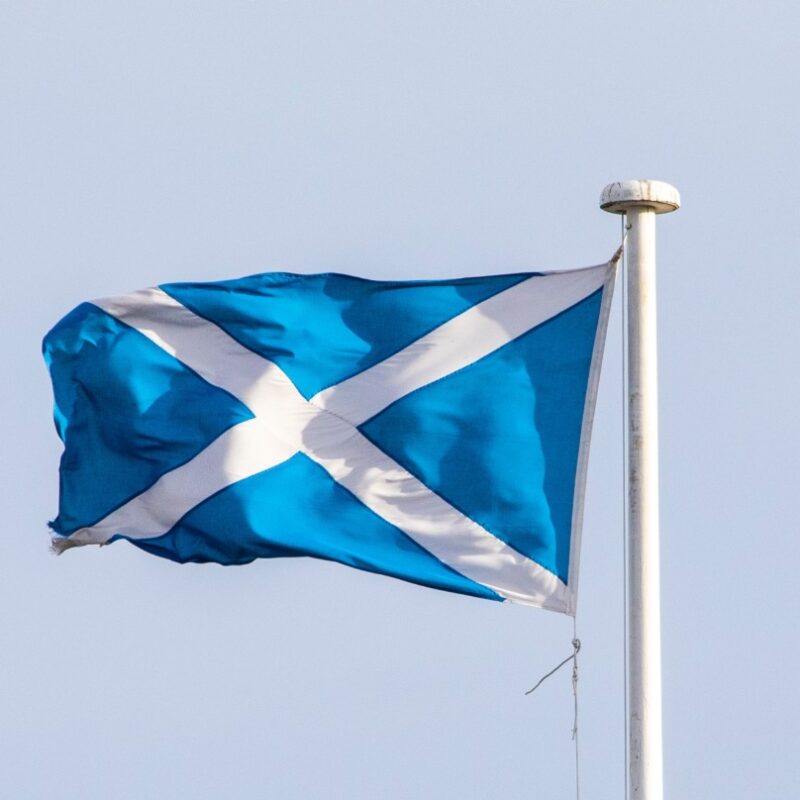 The Scottish Flag flying on a windy day on a flag pole at a Scottish castle.